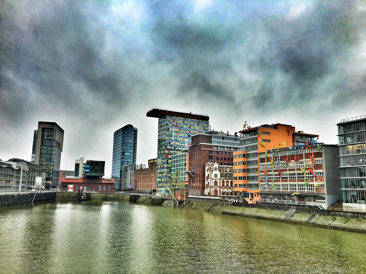 building exterior, architecture, built structure, sky, water, cloud - sky, cloudy, waterfront, city, river, overcast, weather, cloud, residential building, building, residential structure, storm cloud, sea, cityscape, residential district