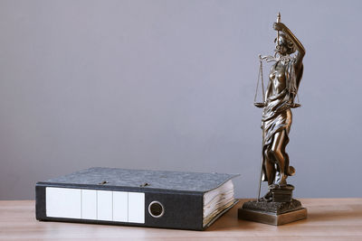 Close-up of statue on table against wall