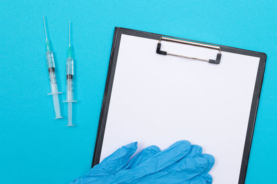 High angle view of pen on table against blue background