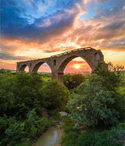 Arch bridge against sky during sunset