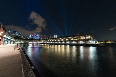 Illuminated bridge over river at night