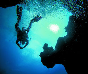 Low angle view of people swimming in sea