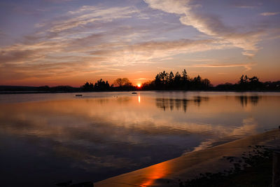 Scenic view of lake against orange sky