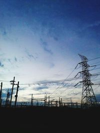Low angle view of power lines against blue sky