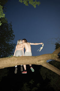 Full length of shirtless man standing against blue sky
