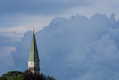 Low angle view of cross and building against sky