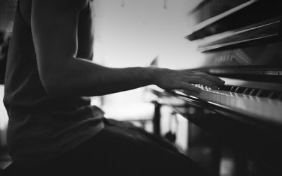 Midsection of man playing piano