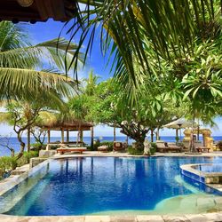 Swimming pool by sea against sky