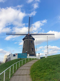 Traditional windmill on field against sky