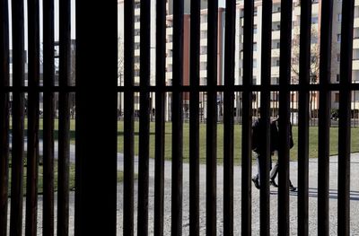 Rear view of silhouette man standing by building