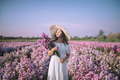 Rear view of woman standing on field against clear sky