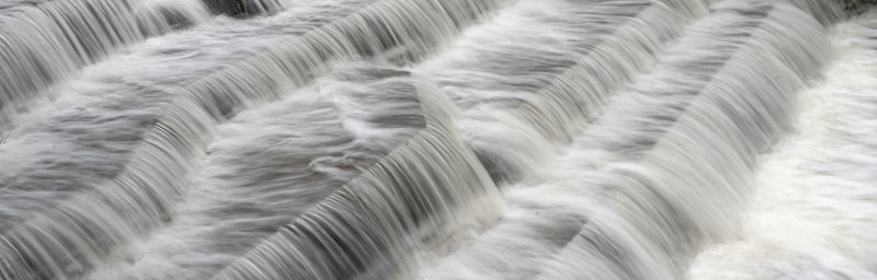 View of water at long exposure to get smooth blurred water effects white water waves over river weir