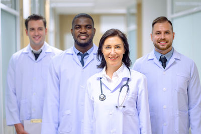 Portrait of female doctor standing against white background