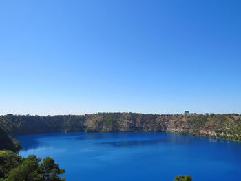 Scenic view of lake against clear blue sky