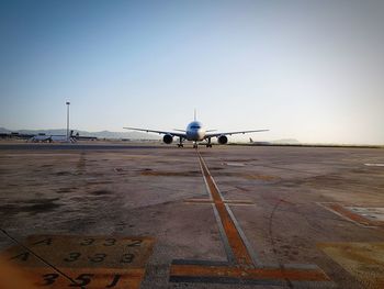 Airplane on runway against sky