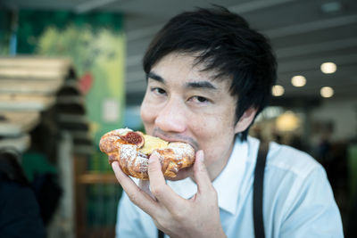 Portrait of man eating food at restaurant