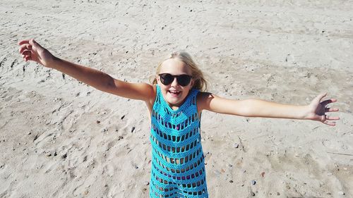 Portrait of smiling young woman with sunglasses on beach