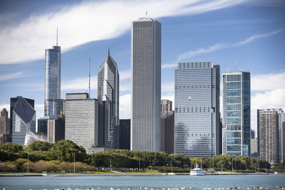 Skyscrapers in city against cloudy sky