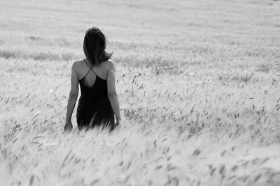 Rear view of woman standing on field