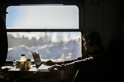 Female entrepreneur looking through window while traveling in train
