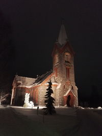 Low angle view of clock tower at night