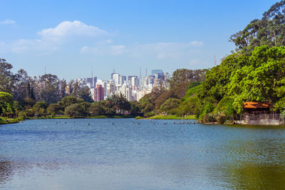 Scenic view of river by buildings against sky