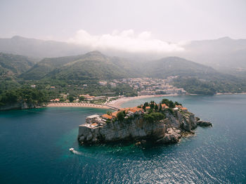 Scenic view of sea and mountains against sky