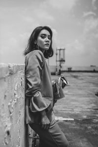 Portrait of beautiful young woman standing against sky