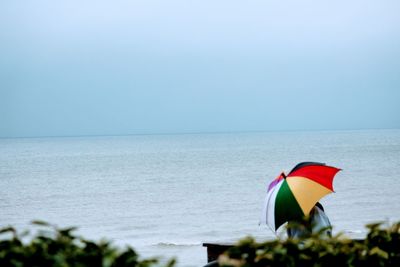 Flag on beach against clear sky