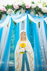 Virgin mary statue against curtain