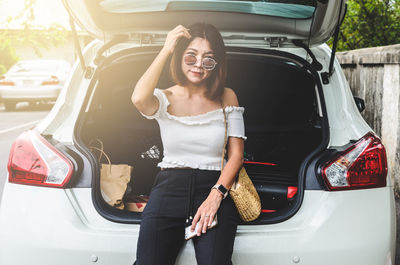 Full length of woman standing in car