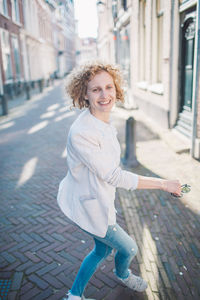 Cheerful woman walking on street in city