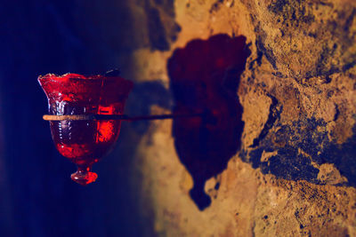 Close-up of red wine glass on rock