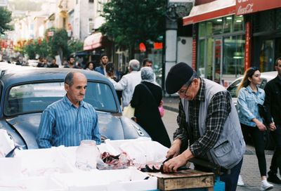 Side view of man cutting meat on table in market