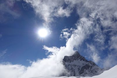 Low angle view of snowcapped mountains against sky