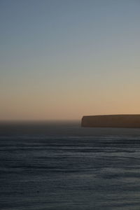 Scenic view of sea against clear sky during sunset