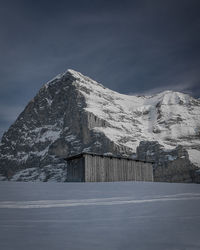 Built structure on snowcapped mountain against sky