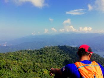 Rear view of man looking at mountain against sky