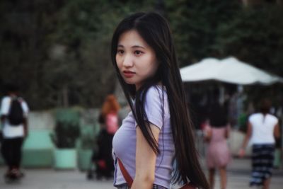 Portrait of a beautiful young woman standing outdoors