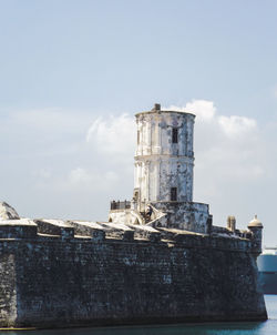 Old tower amidst buildings against sky