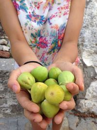 Midsection of girl holding gooseberries