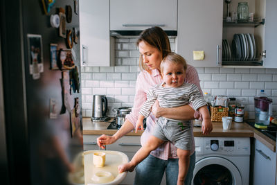 Mom feeds a small child at home with yogurt from a spoon. family concept