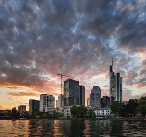 Buildings by city against sky during sunset