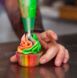 Preparation of a cupcake with colorful cream.