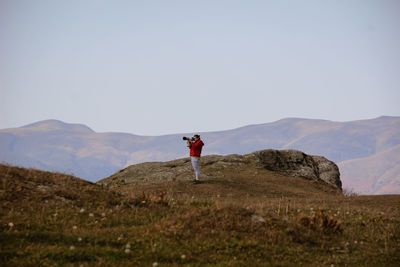 Full length of man standing on mountain against sky