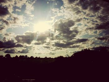 Silhouette of landscape against cloudy sky