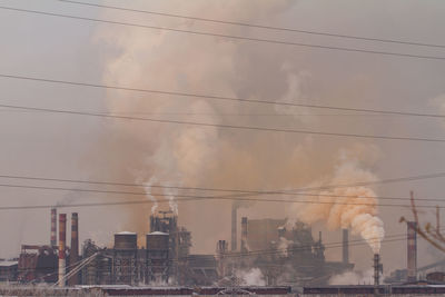 Smoke emitting from chimney against sky