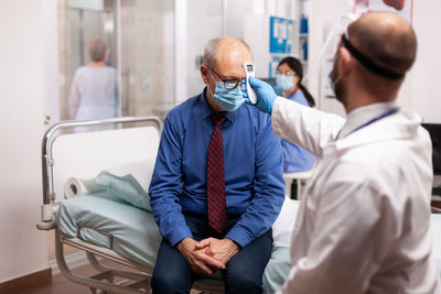 Side view of doctor examining patient in hospital