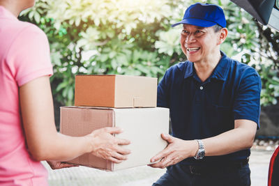 Smiling delivery man giving boxes to woman