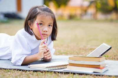 Portrait of girl sitting on book